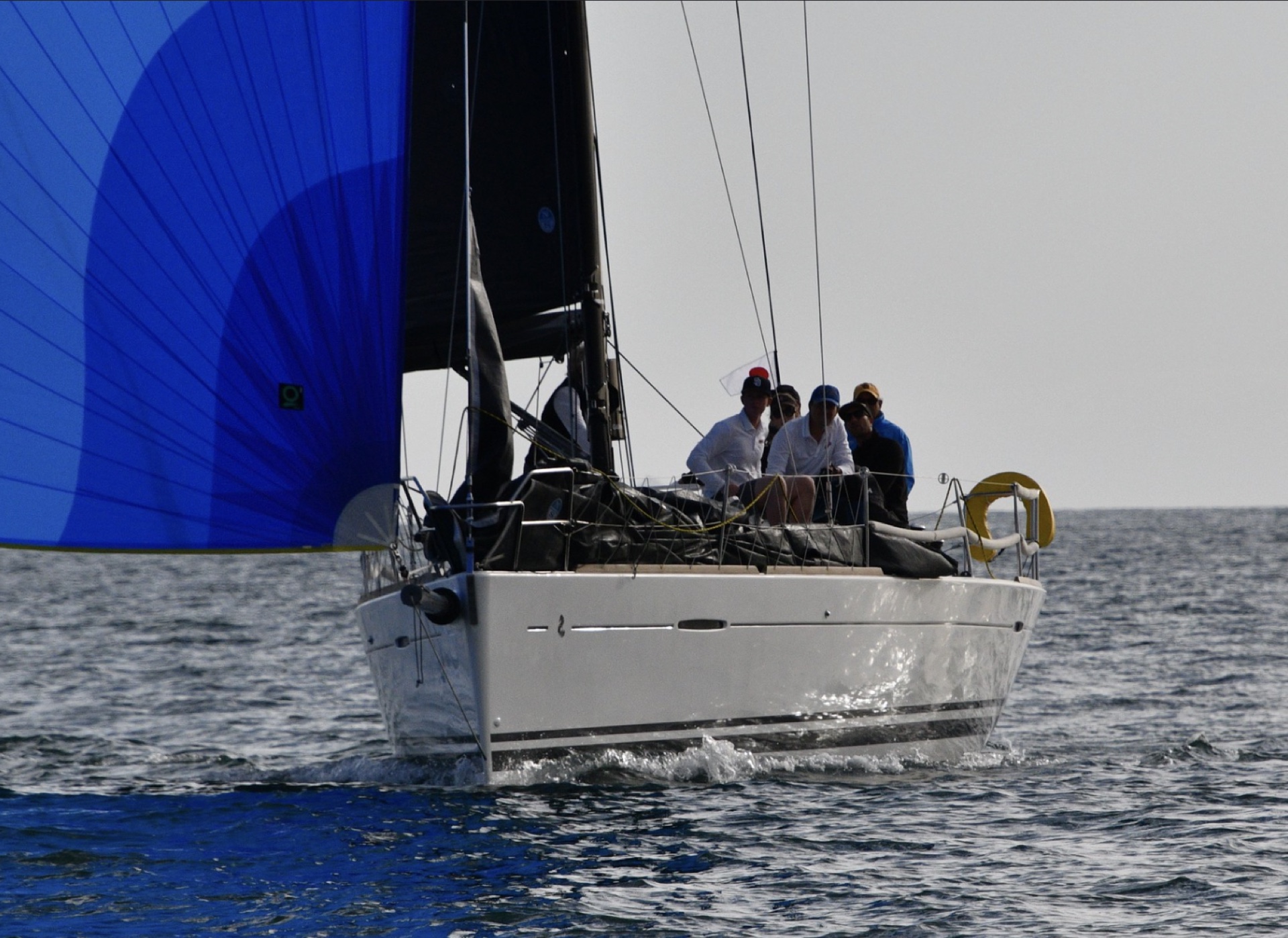 Sailboat surging forward with a large vibrant blue spinnaker flying